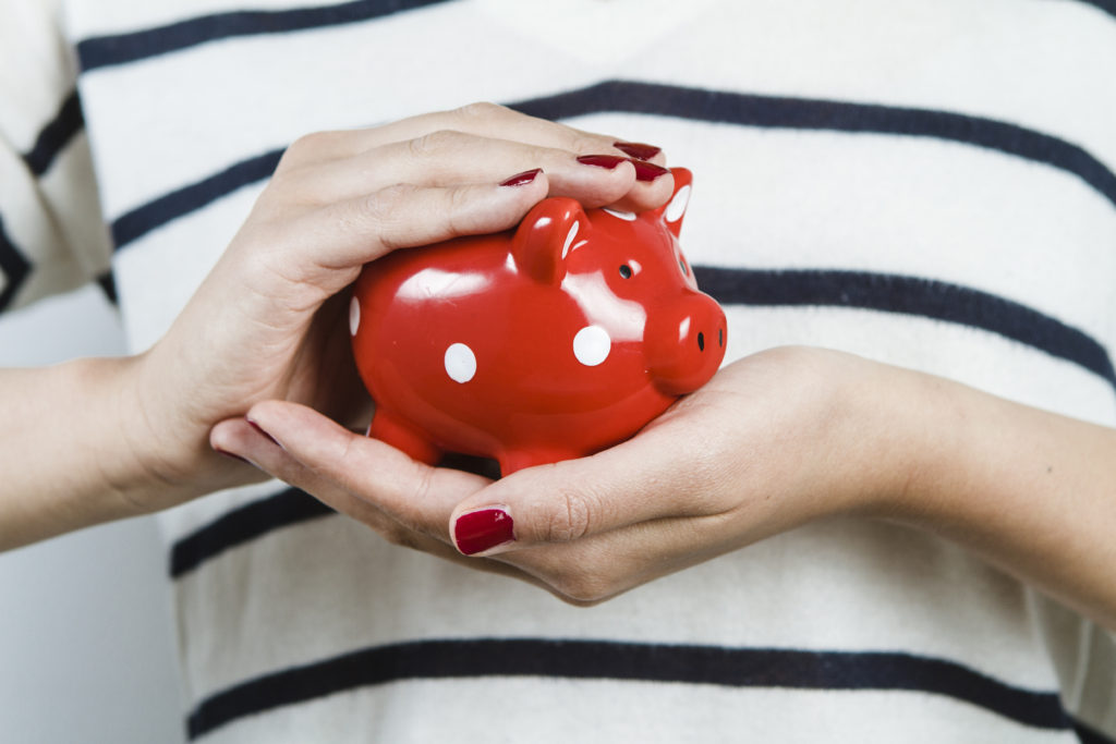Woman holding red piggy bank